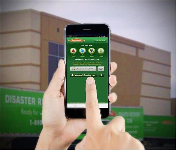a hand holding an iPhone with the SERVPRO Emergency Ready App opened up